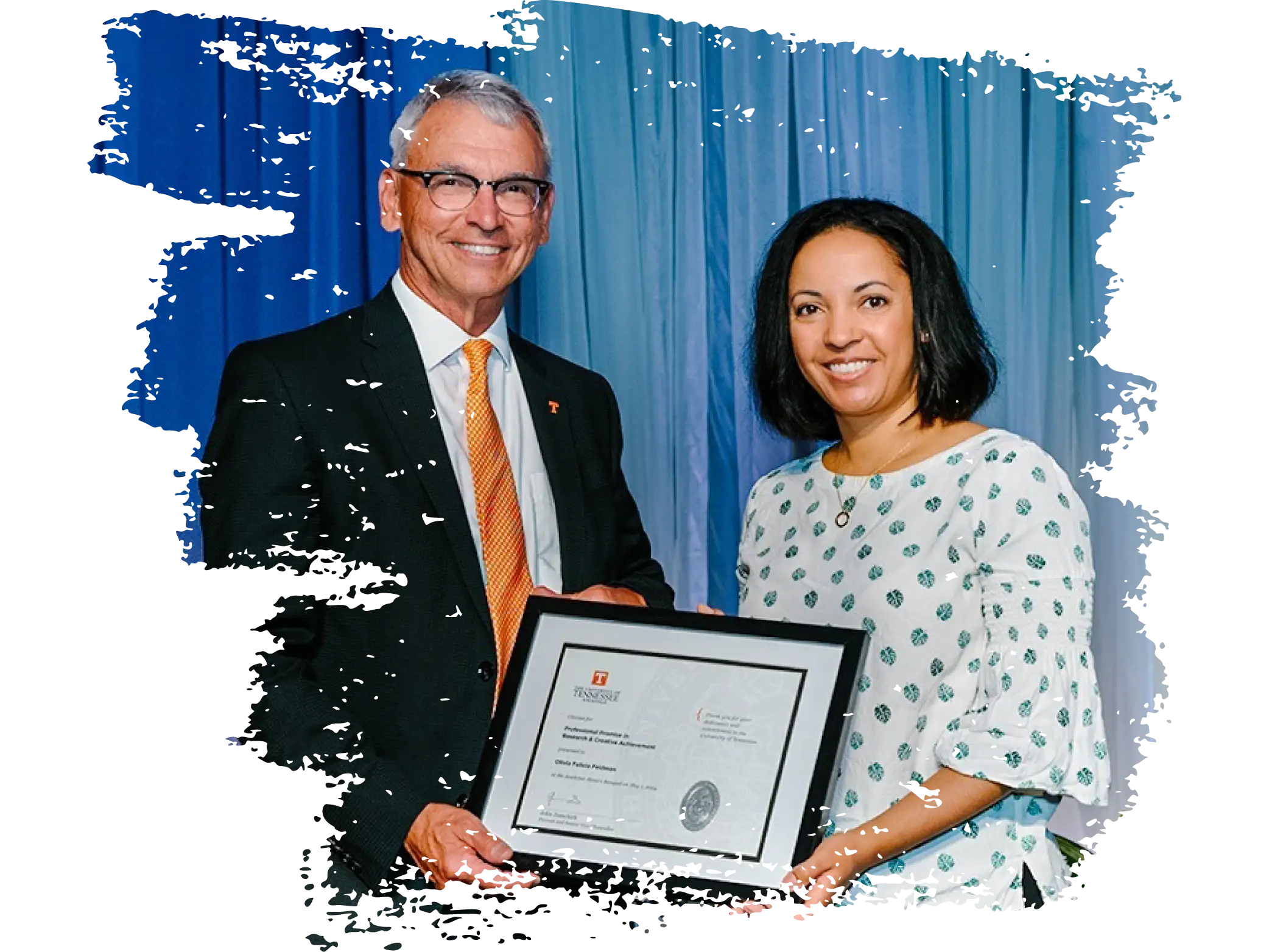 Associate Professor Olivia Feldman holds an award alongside another individual.